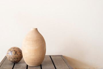Fototapeta ánfora y esfera sobre mesa de madera y fondo liso, elementos decorativos, fotografía minimalista obraz