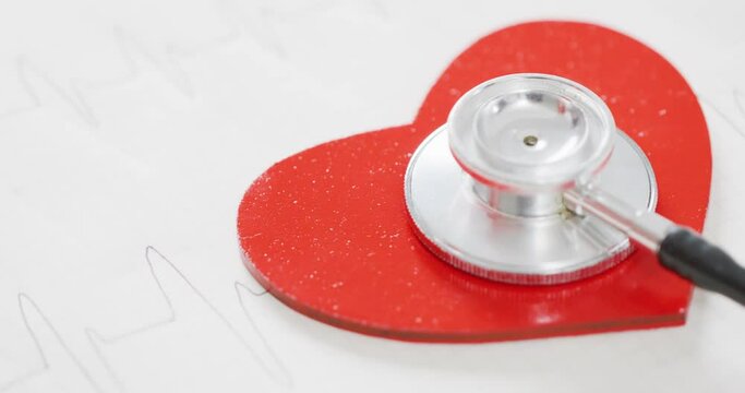 Video of close up of heart and stethoscope on white background
