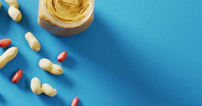 Video of close up of peanut butter on blue background