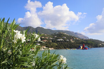 Beautiful beach in Ipsos on Corfu, tourists enjoying a nice summer day at the beach. Greece