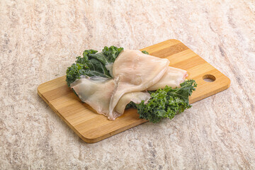 Raw squid over wooden board