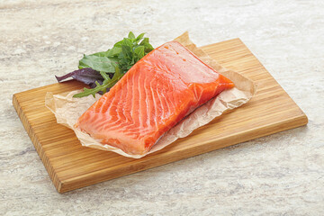 Raw salmon fillet over board