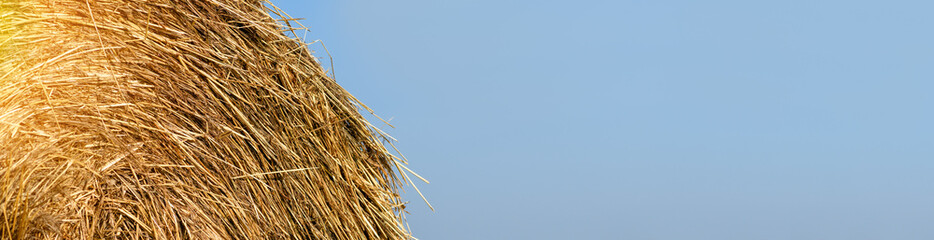 Haystack against the blue sky, close-up. Harvest concept. Rural scenery. Banner
