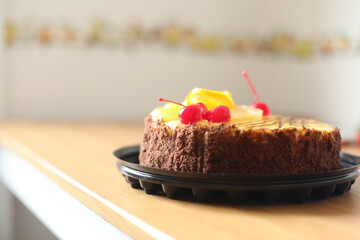 Closeup view of fruits cake on sunny home background. Beautiful delicious bakery. Sweet dessert close-up. Macro. Cherry and chocolate sweets. Birthday party with family. 