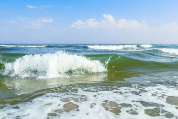 Waves on the sea. Cumulus clouds in the sky