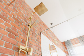 Fototapeta premium Gold faucet for water and white separate high sink on wooden pedestal. Loft style bathroom