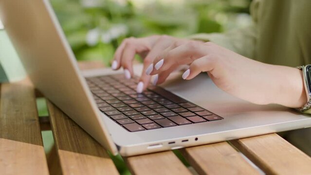 Young student typing on the computer during coffee break. Neat nude manicure. Concept of competent young generation and business woman