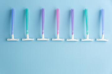 Set of multi-colored disposable razors on a blue background