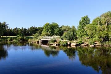 The old wood footbridge at the pond on a sunny day.