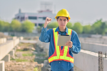 Asian Engineer standing outdoor on site construction posting confident , Engineer construction happy job success with in target planning