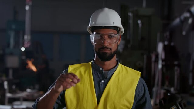 Potrait of young heavy industry worker wearing safety glasses and helmet.