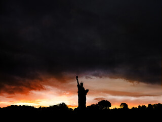 La statue de la liberté à contre jour au coucher de soleil