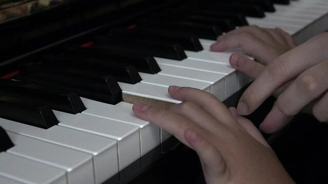 slow shot Close up of kids hands on piano keys with music teacher to play piano instrument.