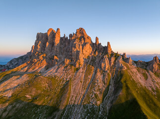 Sunrise in the Dolomites mountains with fog and mist rolling around the peaks. Hiking path leading to the hills. 
