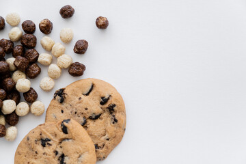 top view of cereal balls with vanilla and chocolate flavors near tasty cookies isolated on white.