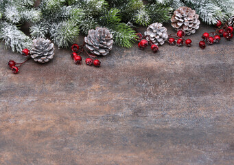 Natürlicher Weihnachtshintergrund mit Tannenzweigen, roten Beeren und Kieferzapfen.