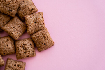 top view of chocolate cereal puffs isolated on pink with copy space.