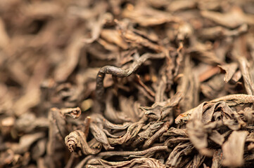 Large-leaved black tea in bulk on the table. Close-up of the surface texture