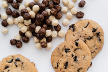 top view of cereal balls near chocolate chip cookies isolated on white.