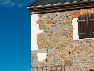 Wall of a country house with old stones. Renovated facade of a building in a rural area....