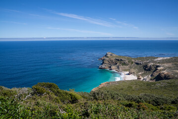 A spectacular view of the blue sea, rocky headland, and Dias beach at Cape Point in the Table Mountain National Park.