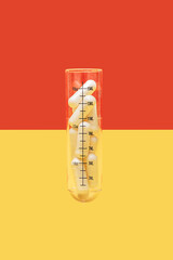 Lab glass test tube with medicine pills on a yellow and red background with copy space. Creative concept of overdose, placebo and addiction to food supplement.