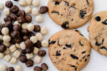 top view of cereal balls with vanilla and chocolate flavors near delicious cookies isolated on white.