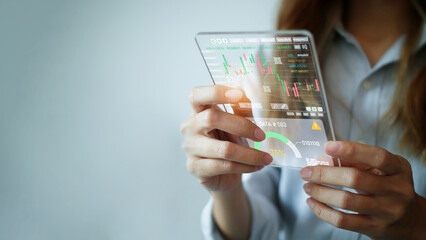 A young woman is looking at a stock chart or a large clip of currency through a hologram screen.