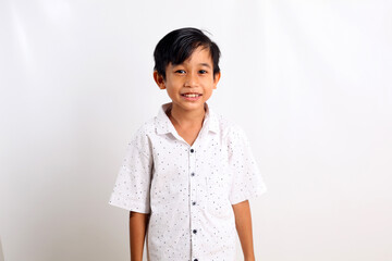 Asian boy in white standing while smiling. Isolated on white background