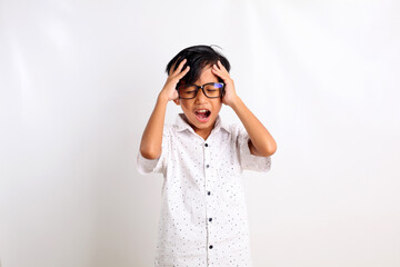 Stressed asian boy standing while holding his head. Isolated on white background