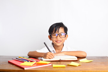 Happy asian schoolboy studying in the classroom. Isolated on white background