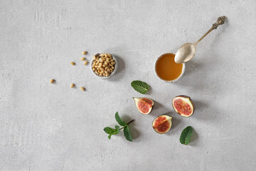 Fototapeta na wymiar Ingredients for bruschetta with ripe figs, pine nuts and honey on a light background. top view, copy space