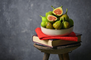 Ripe figs heap on book and old wooden stool