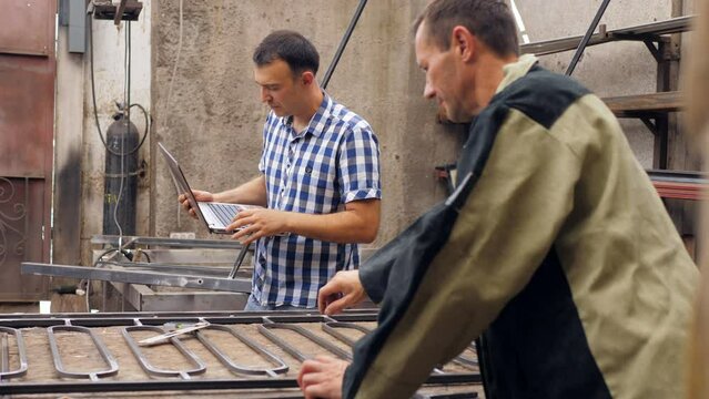 The engineer performs inspection and quality control of the manufacture of metal products in a private workshop.