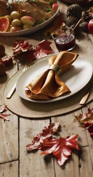 Vertical video of roasted turkey, plates and table with autumn decoration