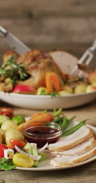 Vertical video of roasted turkey, plates and table with autumn decoration