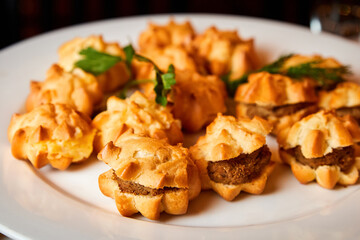 Tartlets with pate and herbs on a white plate