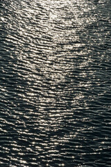 The silver surface of the sea water illuminated by the moonlight