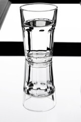 A glass with clean clear water with reflection and sharp shadows