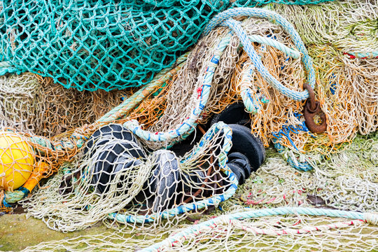 blue fishing net on a pontoon with its ropes and floats covered with morning frost