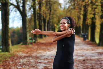 positive middle age woman stretching outdoors preparing for exercise in sportswear