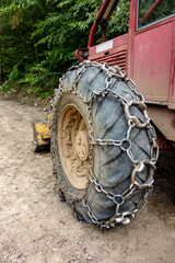 Fototapeta na wymiar Traction chain on the big wheel of the towing forest vehicle