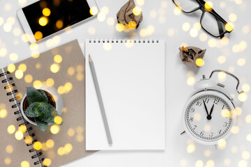 Empty notebook with phone on white table. Resolutions, plan, goals, checklist, idea concept. Top view, flat lay, copy space. 2023. Christmas, New Year. White Page for your write. Goal list concept