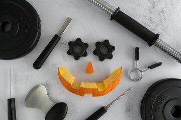 Dumbbell barbell weight plates with Halloween pumpkin pieces cut out. Carved face elements with...