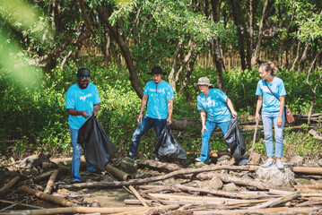 Group of diverse people volunteer teamwork ,environment conservation,volunteering help to pick up plastic and foam garbage on mangrove forest park area and ocean beach.