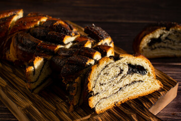 Appetizing bun with poppy seeds on an old background