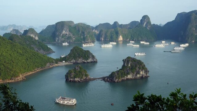 Panning shot showing tour boats and dramatic karst scenery at Halong Bay, northern Vietnam. 