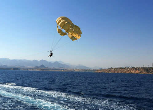 una mongolfiera gialla che si libra in aria sul mare