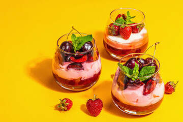 Delicious Italian dessert panna cotta with sweet cherry sauce, strawberry jam, fresh berries, mint