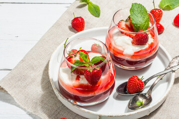 Italian dessert panna cotta in glass with strawberries. Healthy sweet food, hard light, dark shadow